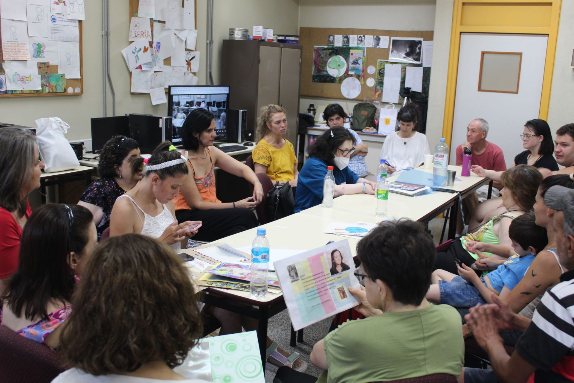 Perosnas reunidas al rededor de una mesa en el taller.