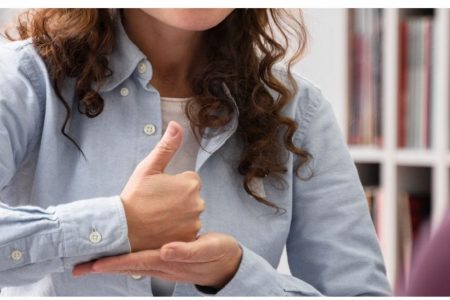 Mujer hablando por lengua de señas con otras personas