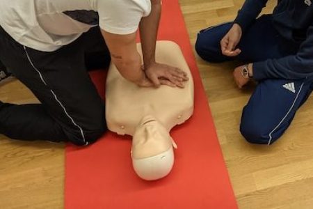 Dos personas practican RCP con un mucñeco